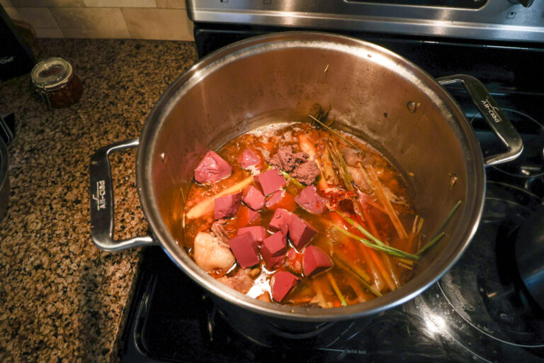 adding finishing touches to bun bo hue